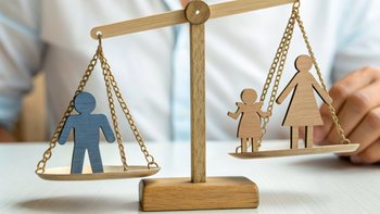 Child Care Cost Concept. Wooden scale balancing icons of parents and child, symbolizing childcare fees and family responsibilities